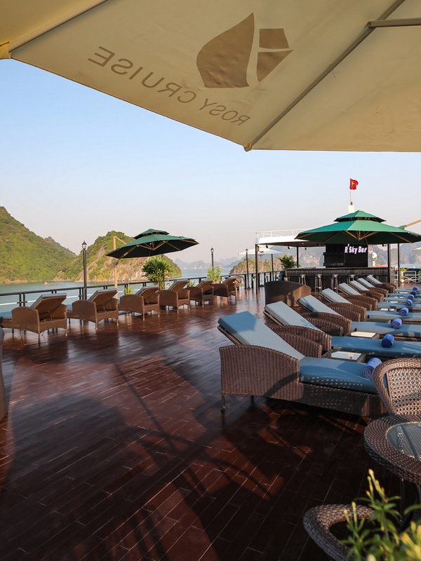 Stunning Halong Bay cruise balcony with panoramic views, relaxing lounge area, perfect for exploring.