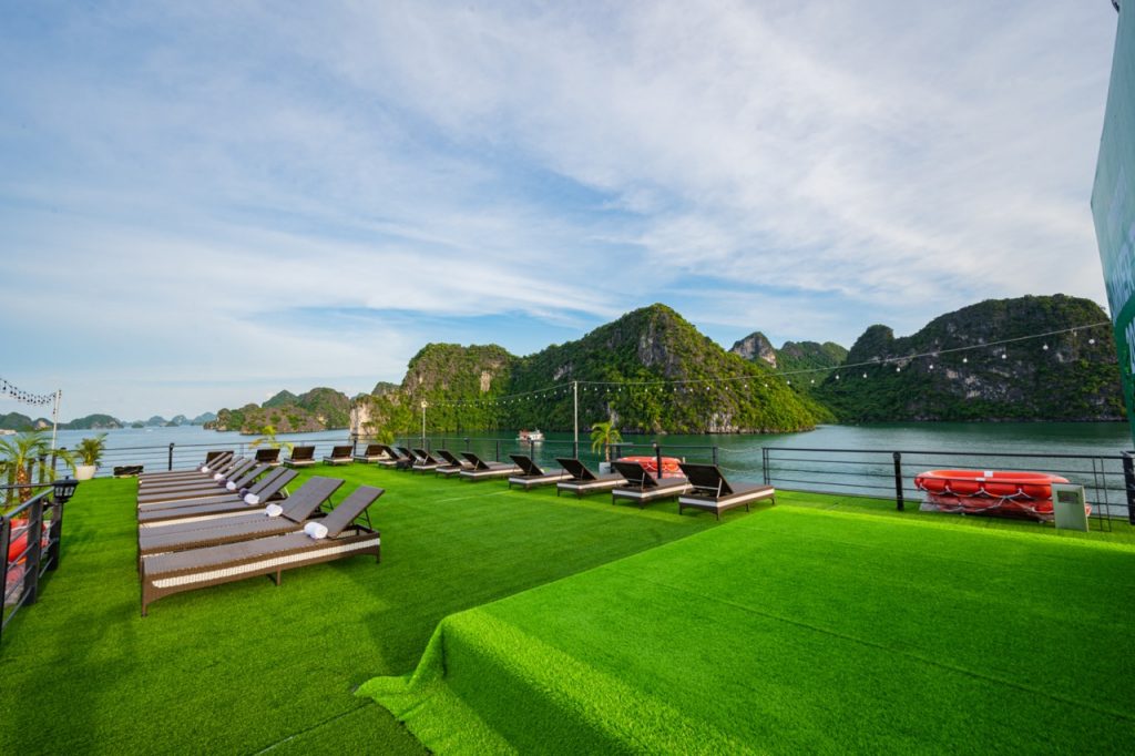 Relaxing cruise deck with scenic Halong Bay views, perfect for sunbathing and enjoying the tranquil.