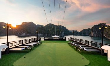Stunning view of Halong Bay from cruise balcony at sunset, with lush islands and calm waters.
