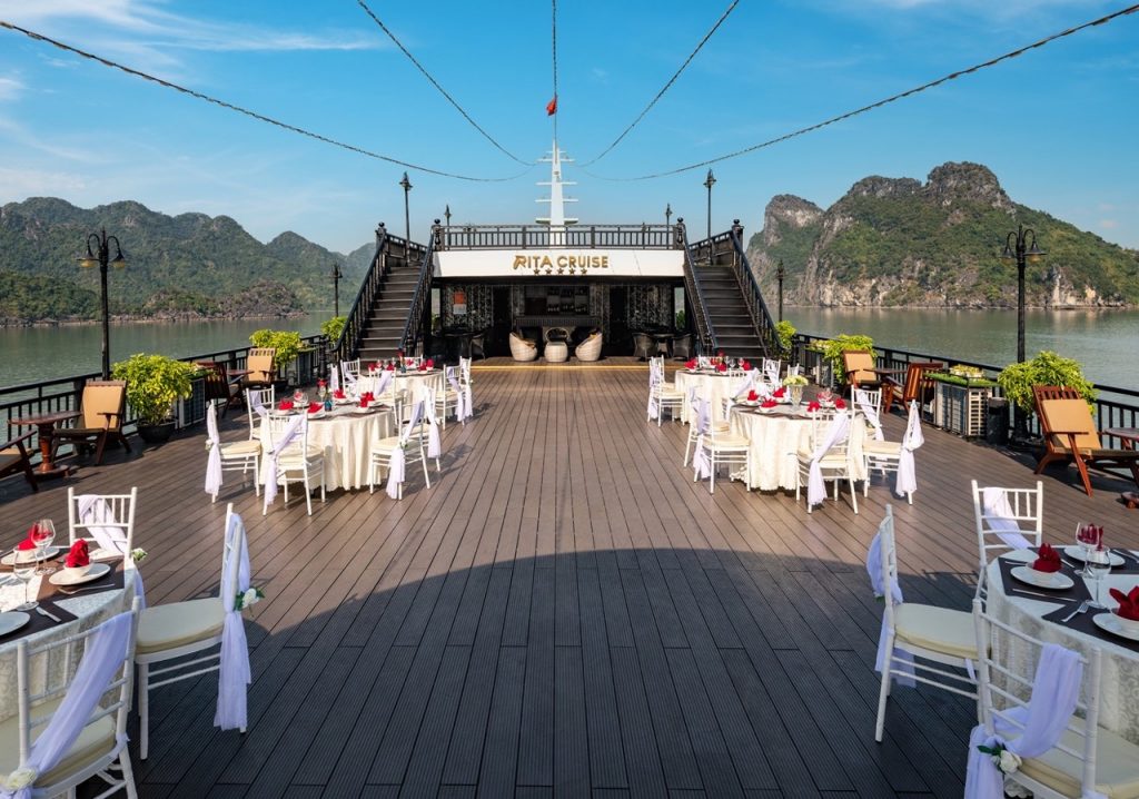 Stunning Halong Bay cruise balcony with scenic mountain views and elegant dining area.