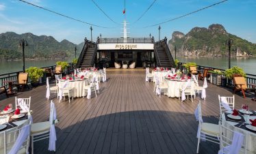 Stunning Halong Bay cruise balcony with scenic mountain views and elegant dining area.