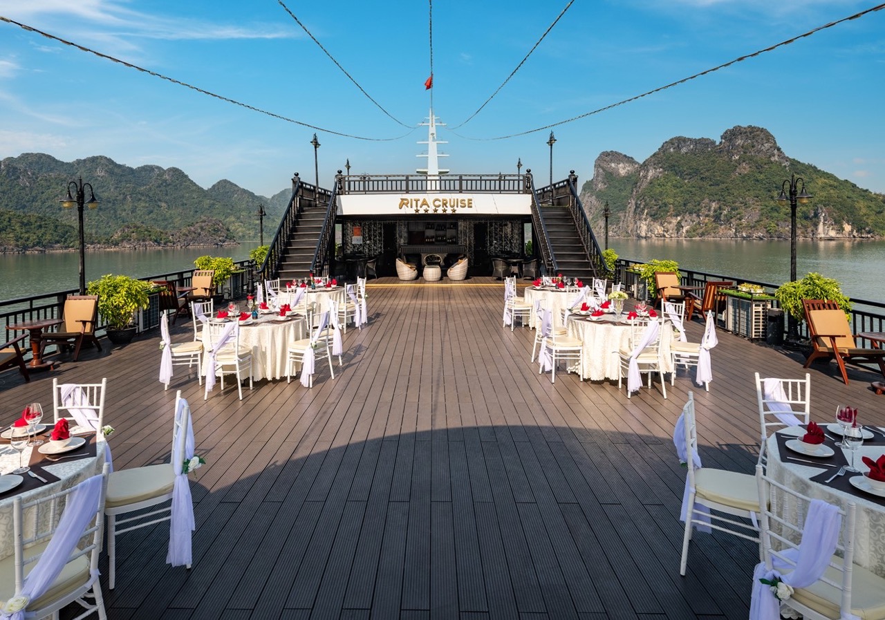 Stunning Halong Bay cruise balcony with scenic mountain views and elegant dining area.