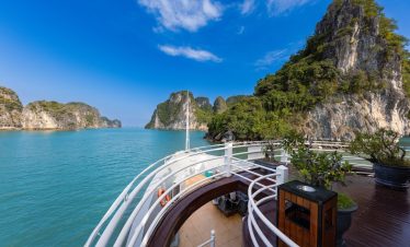 Halong Bay cruise balcony with stunning limestone karsts and turquoise waters.