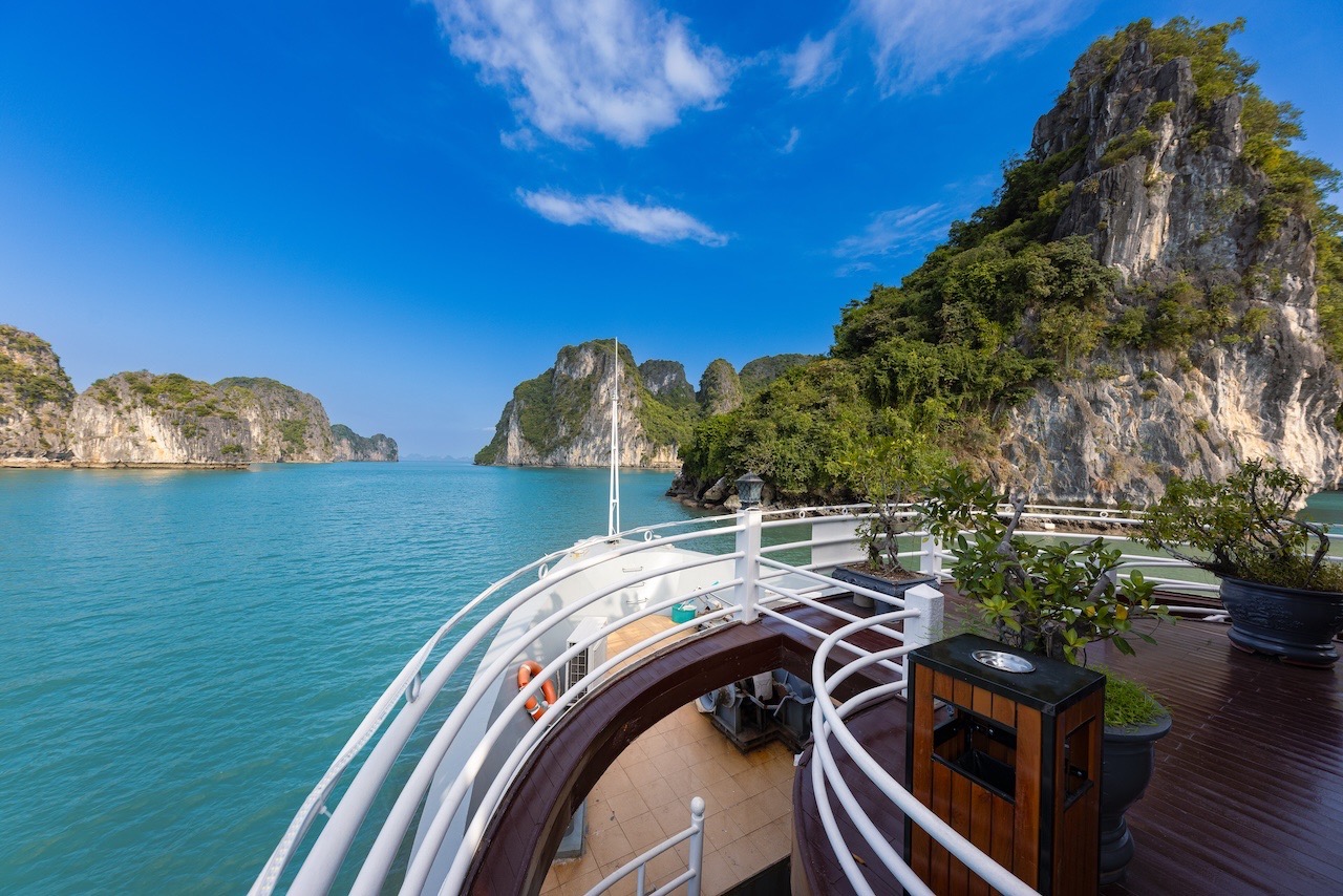 Halong Bay cruise balcony with stunning limestone karsts and turquoise waters.
