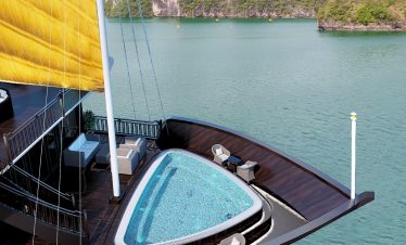 Luxury cruise balcony view of Lan Ha Bay with scenic limestone islands and calm waters.