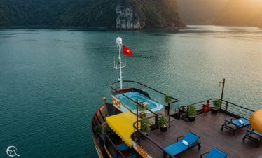 Stunning view from cruise balcony in Halong Bay with calm waters and lush islands.