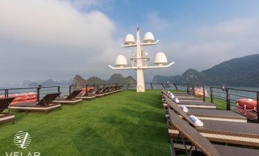 Luxury cruise balcony overlooking Halong Bay with scenic mountain views and relaxing atmosphere.