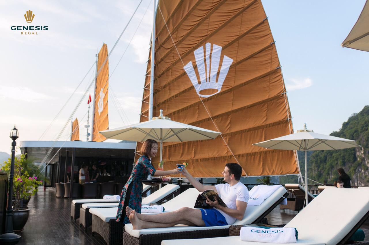 Relaxing couple enjoying a scenic Halong Bay cruise balcony with stunning views and luxurious amenit.