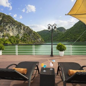Serene lake view with outdoor lounge, sun umbrellas, and refreshing cocktails, perfect for relaxation in Vietnam.