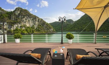 Serene lake view with outdoor lounge, sun umbrellas, and refreshing cocktails, perfect for relaxation in Vietnam.