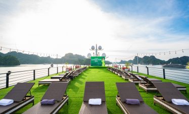 Scenic cruise deck with sun loungers overlooking Halong Bay, perfect for relaxing and enjoying the s.