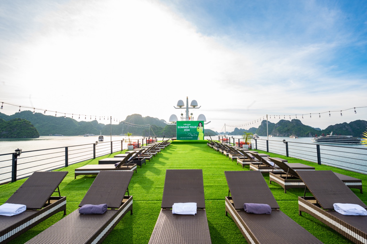 Scenic cruise deck with sun loungers overlooking Halong Bay, perfect for relaxing and enjoying the s.