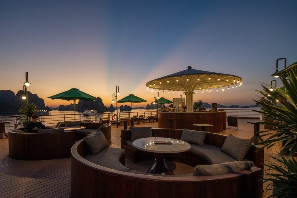 Relaxing cruise deck scene at sunset with comfortable seating and scenic ocean view in Bai Tu Long B.