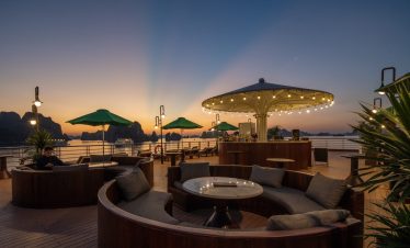 Relaxing cruise deck scene at sunset with comfortable seating and scenic ocean view in Bai Tu Long B.