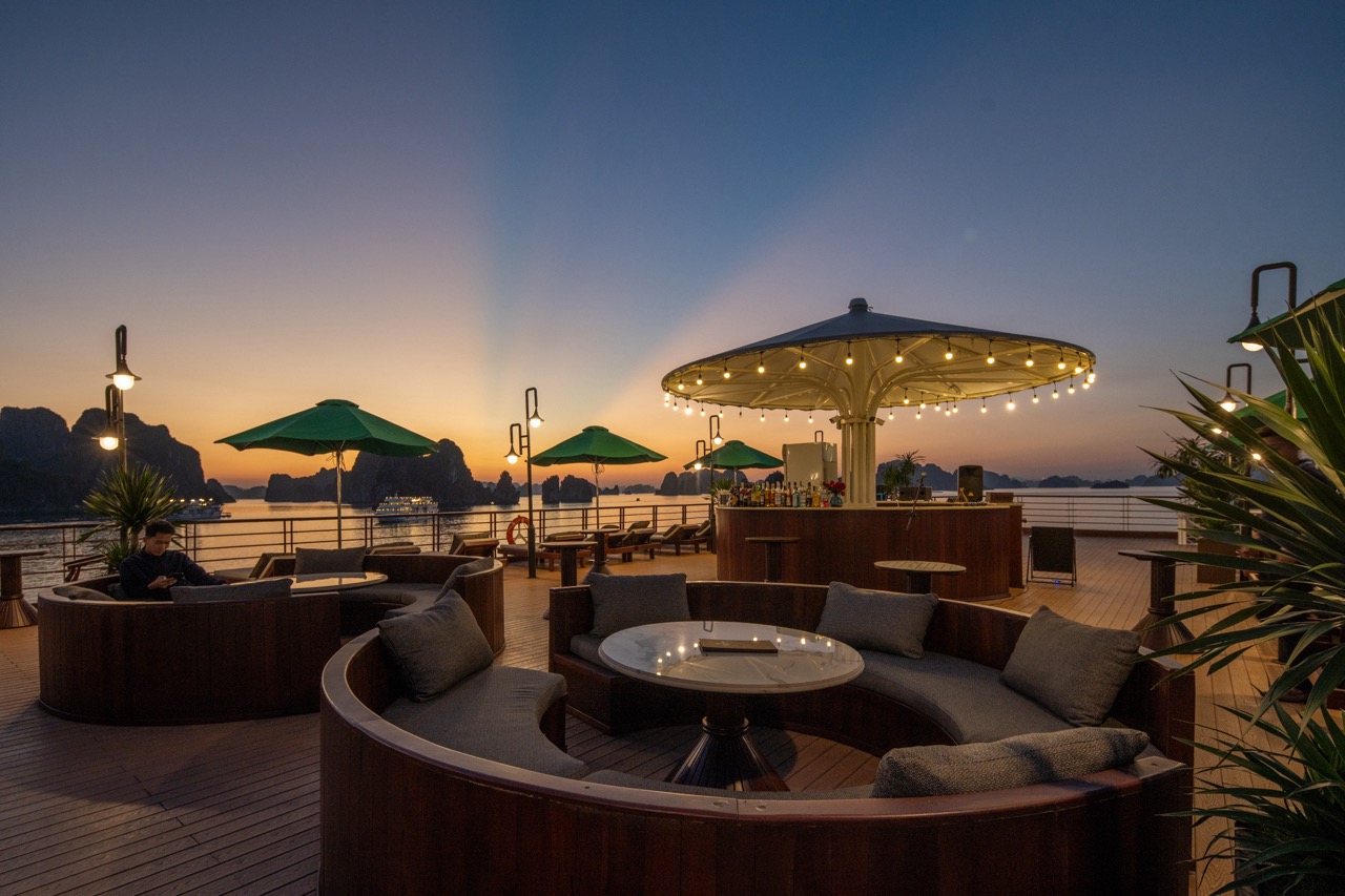 Relaxing cruise deck scene at sunset with comfortable seating and scenic ocean view in Bai Tu Long B.