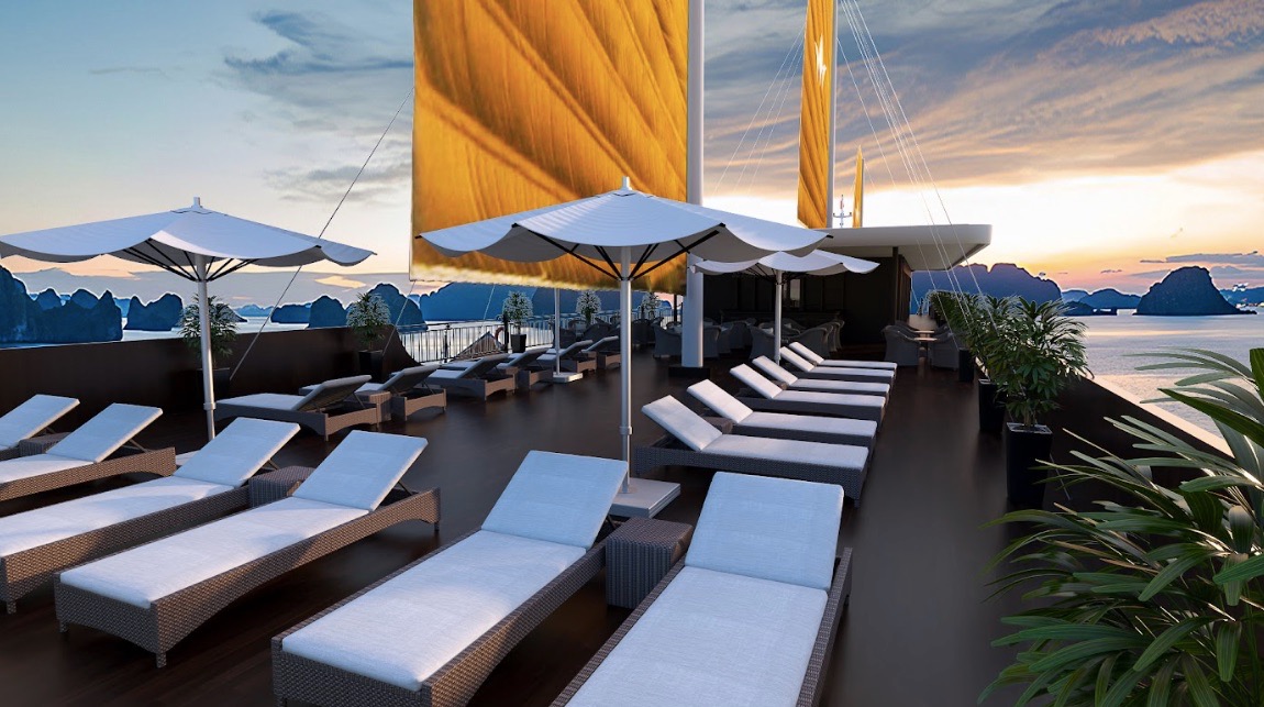 Luxury cruise balcony view of Lan Ha Bay at sunset with sun loungers and umbrellas.