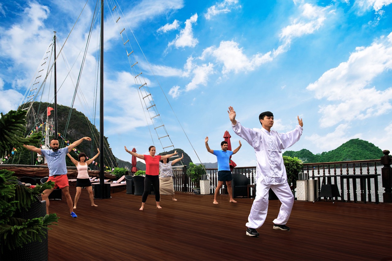 Yoga session on cruise deck with scenic Halong Bay backdrop, peaceful and relaxing atmosphere.