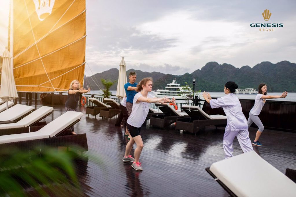 Yoga class on cruise deck with scenic Halong Bay views, people practicing yoga, peaceful and scenic.