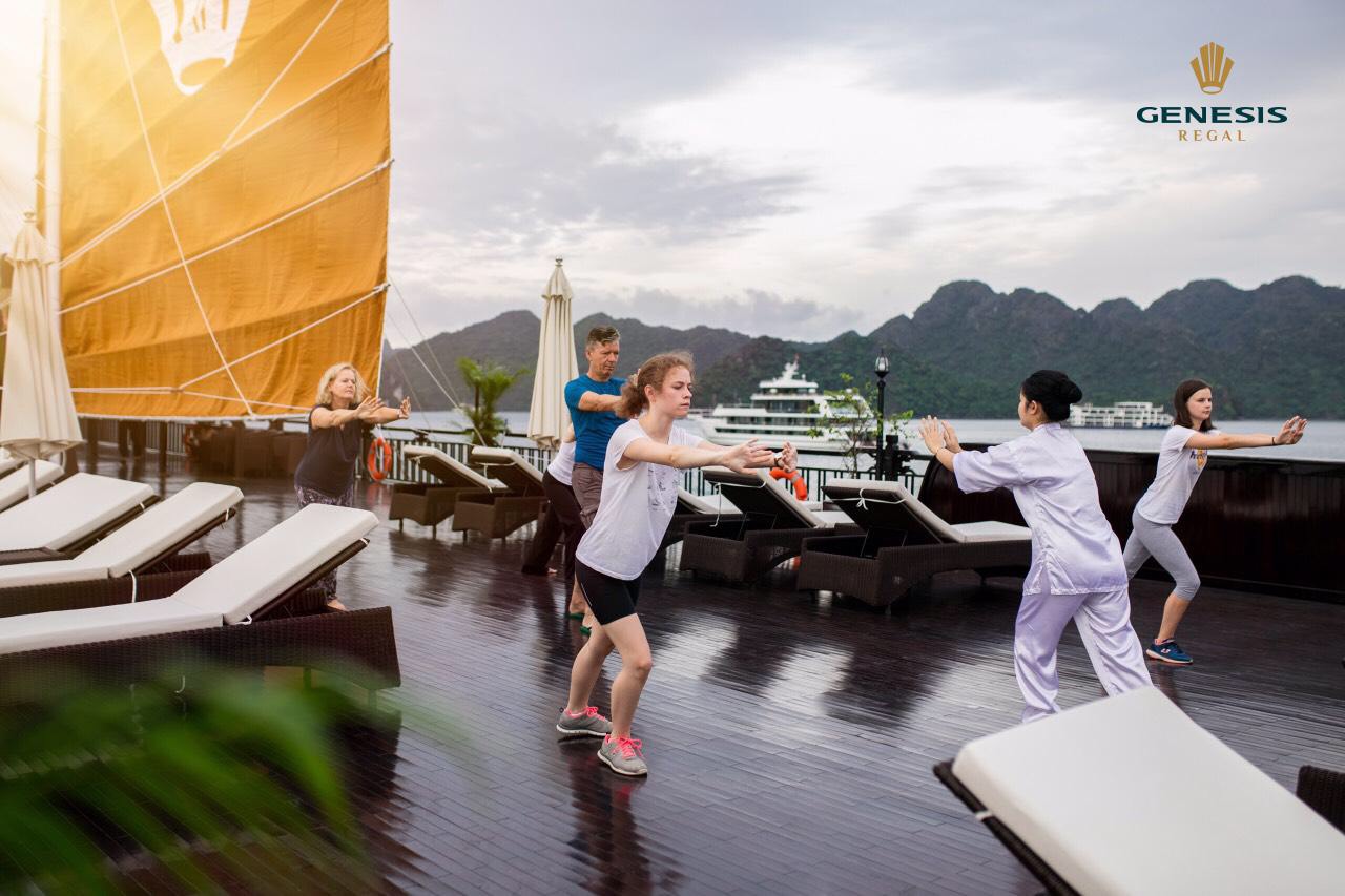 Yoga class on cruise deck with scenic Halong Bay views, people practicing yoga, peaceful and scenic.