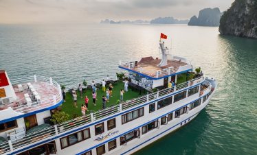 Scenic view of Swan Cruise boat in Halong Bay with passengers enjoying the outdoor deck.