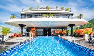 Luxury cruise balcony view in Halong Bay with swimming pool and modern amenities.
