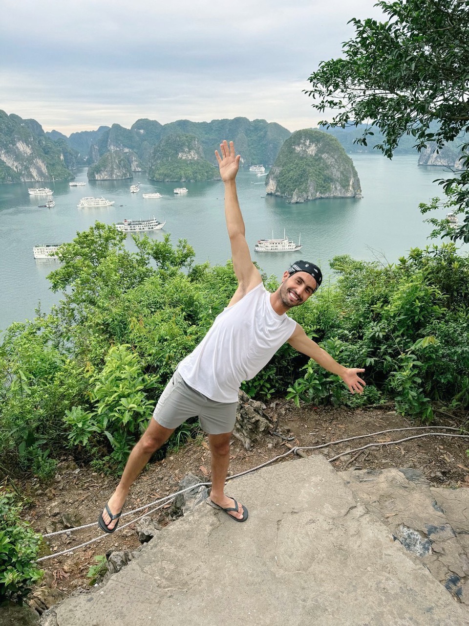 Scenic view of limestone islands in Halong Bay with lush greenery and boats, perfect for trekking an.