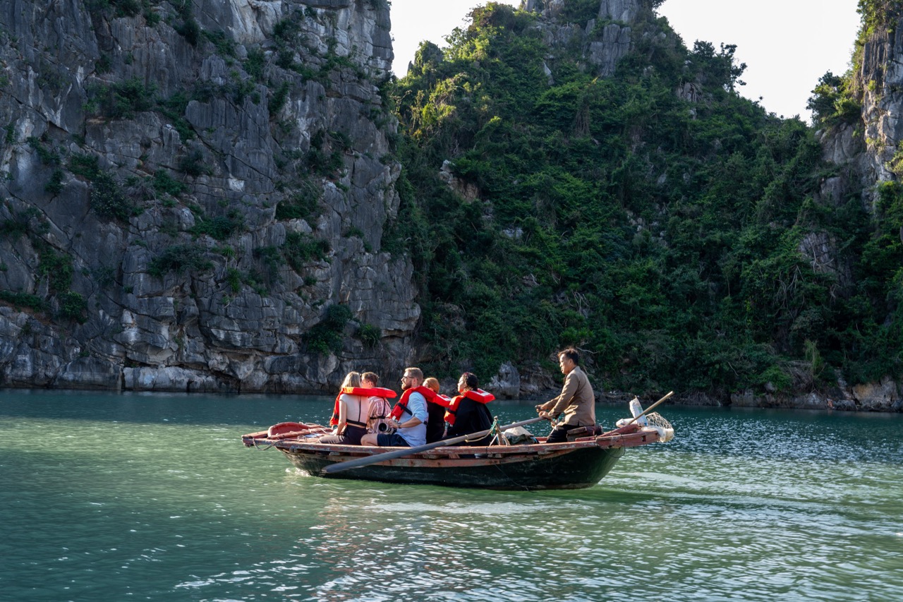 Kayaking tour on Bai Tu Long Bay featuring scenic limestone cliffs and emerald waters.