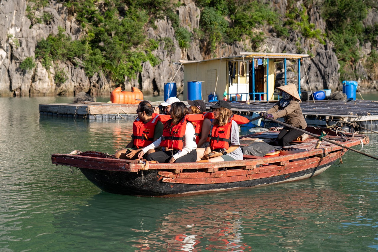 Kayaking adventure on Halong Bay cruise balcony with scenic limestone cliffs.