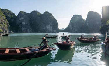 Scenic Bai Tu Long Bay with boats and limestone karsts under bright sky, perfect for cruising and ex.