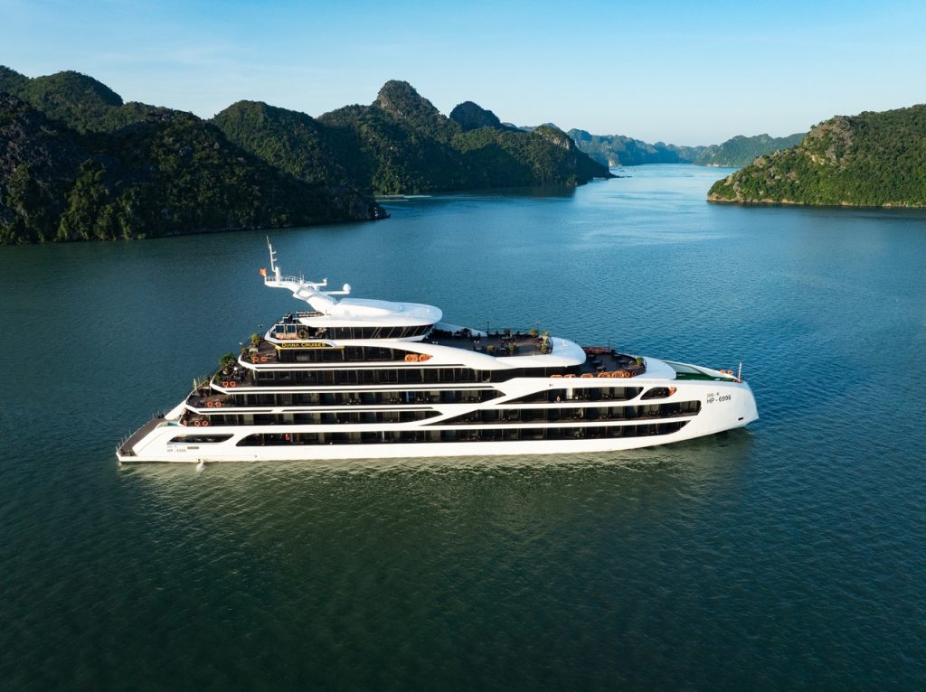 Luxury cruise ship sailing on Lan Ha Bay with scenic limestone karsts and calm waters.