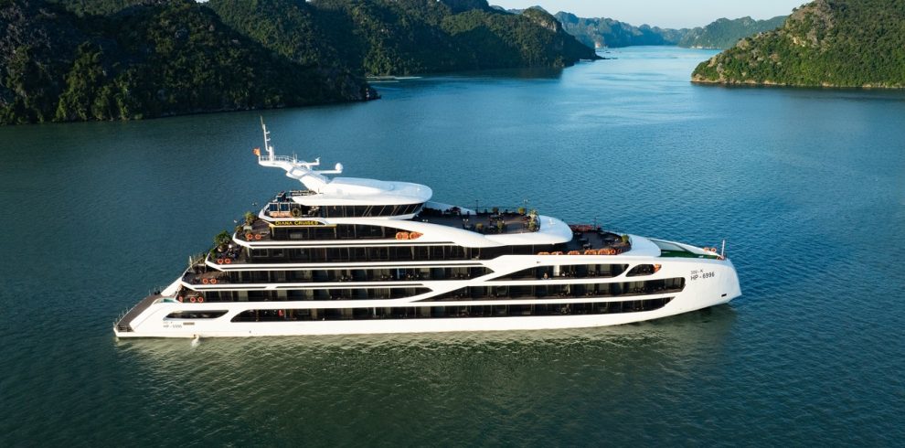 Luxury cruise ship sailing on Lan Ha Bay with scenic limestone karsts and calm waters.