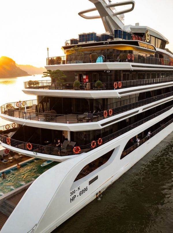 Stunning view of a modern cruise ship sailing in Lan Ha Bay at sunset, perfect for luxury travel and.