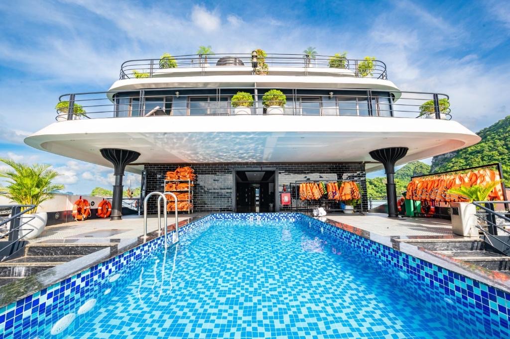 Stunning view of a modern cruise ship with a swimming pool on Lan Ha Bay, surrounded by lush green i.
