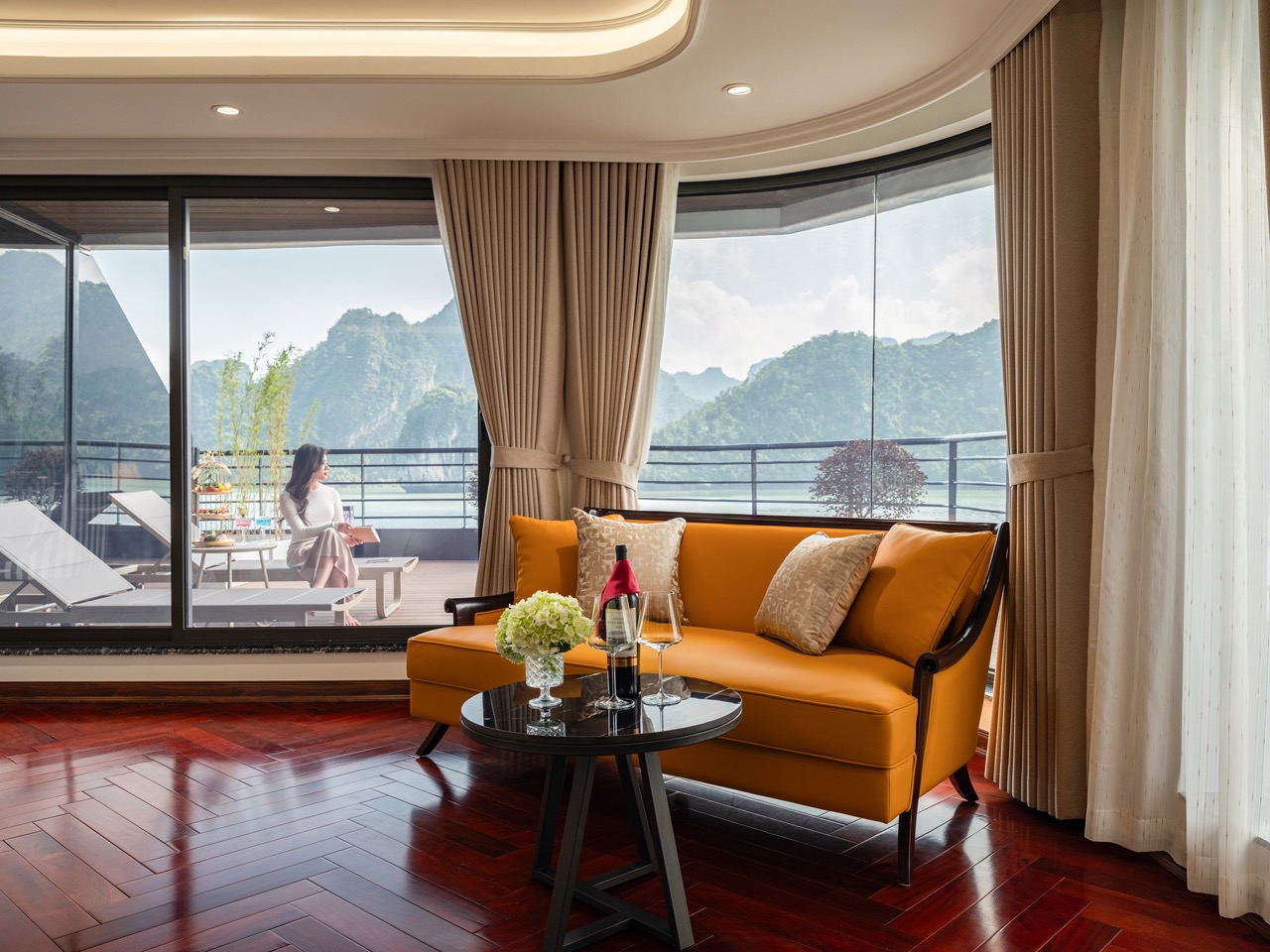 Stunning view from a cruise balcony in Halong Bay with lush mountains and calm waters, perfect for a.