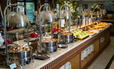 Elegant buffet setup on a luxury cruise in Lan Ha Bay, showcasing diverse dishes and a sophisticated.