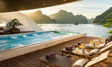 Stunning Lan Ha Bay cruise balcony scene showcasing mountain views, tranquil waters, and sunset ambi.