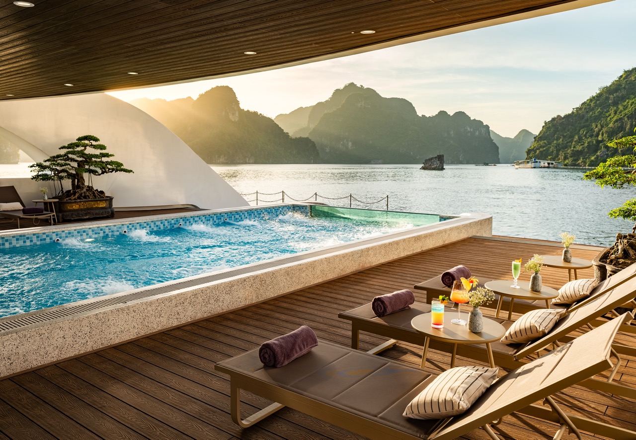 Stunning Lan Ha Bay cruise balcony scene showcasing mountain views, tranquil waters, and sunset ambi.