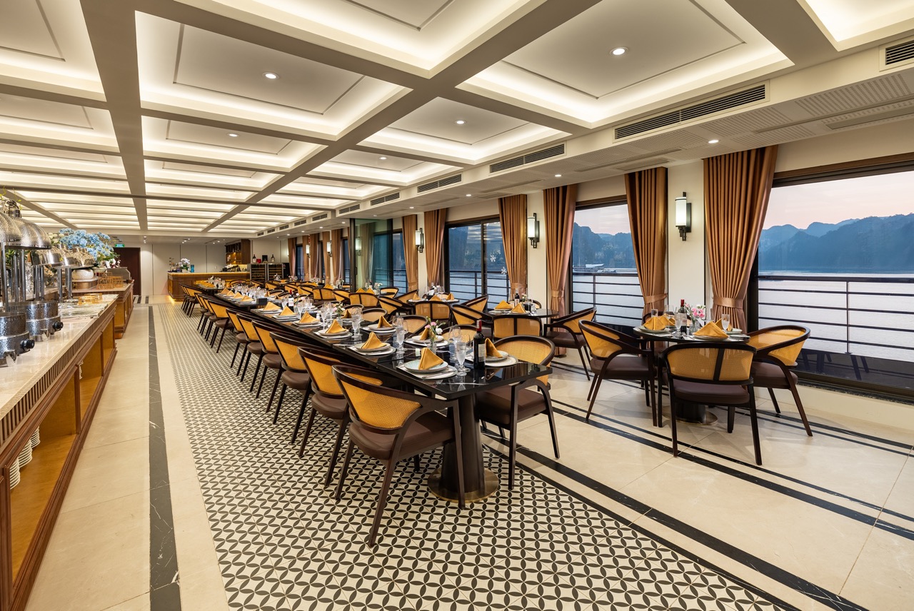 Elegant cruise dining room overlooking Halong Bay with panoramic windows and stylish decor.