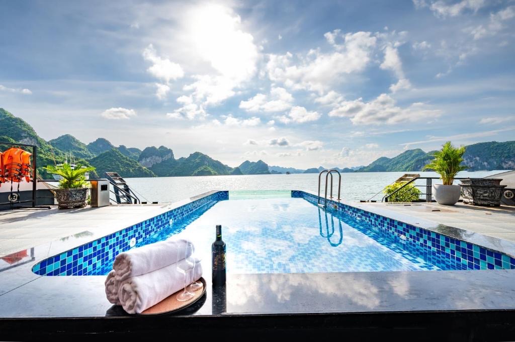 Relaxing pool on Lan Ha Bay cruise with mountain views and clear blue sky, perfect for a tranquil ge.