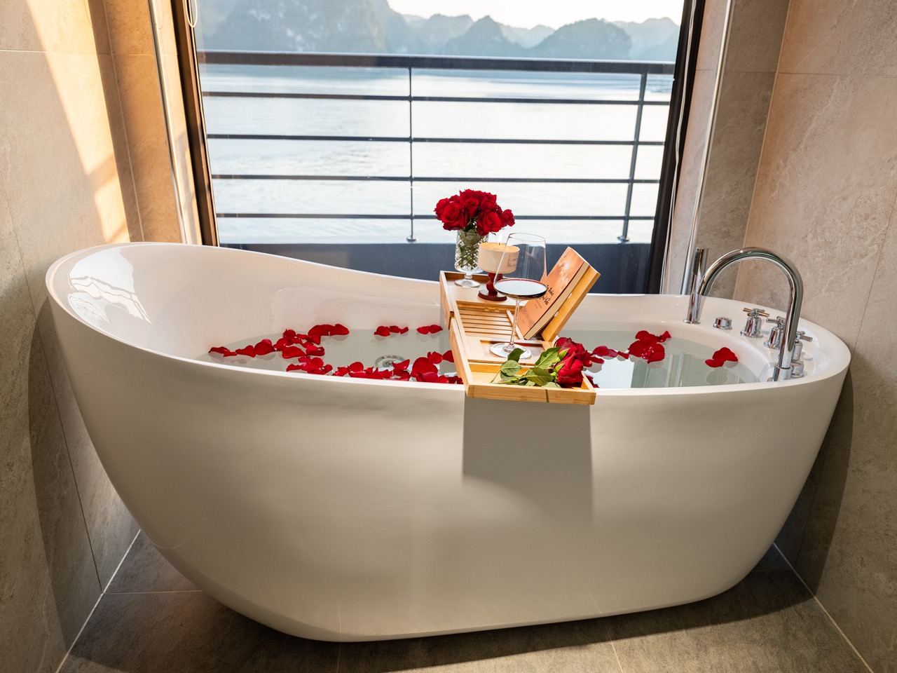 Scenic view of a luxurious bathtub filled with water and rose petals overlooking Lan Ha Bay, perfect.