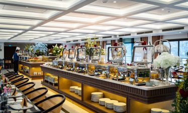 Elegant cruise dining area with buffet setup, modern decor, and scenic bay views, perfect for a rela.