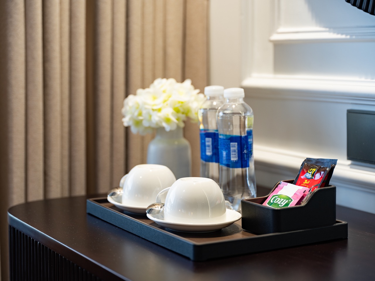 Luxurious Lan Ha Bay cruise balcony with tea, water bottles, and scenic views for a relaxing getaway.