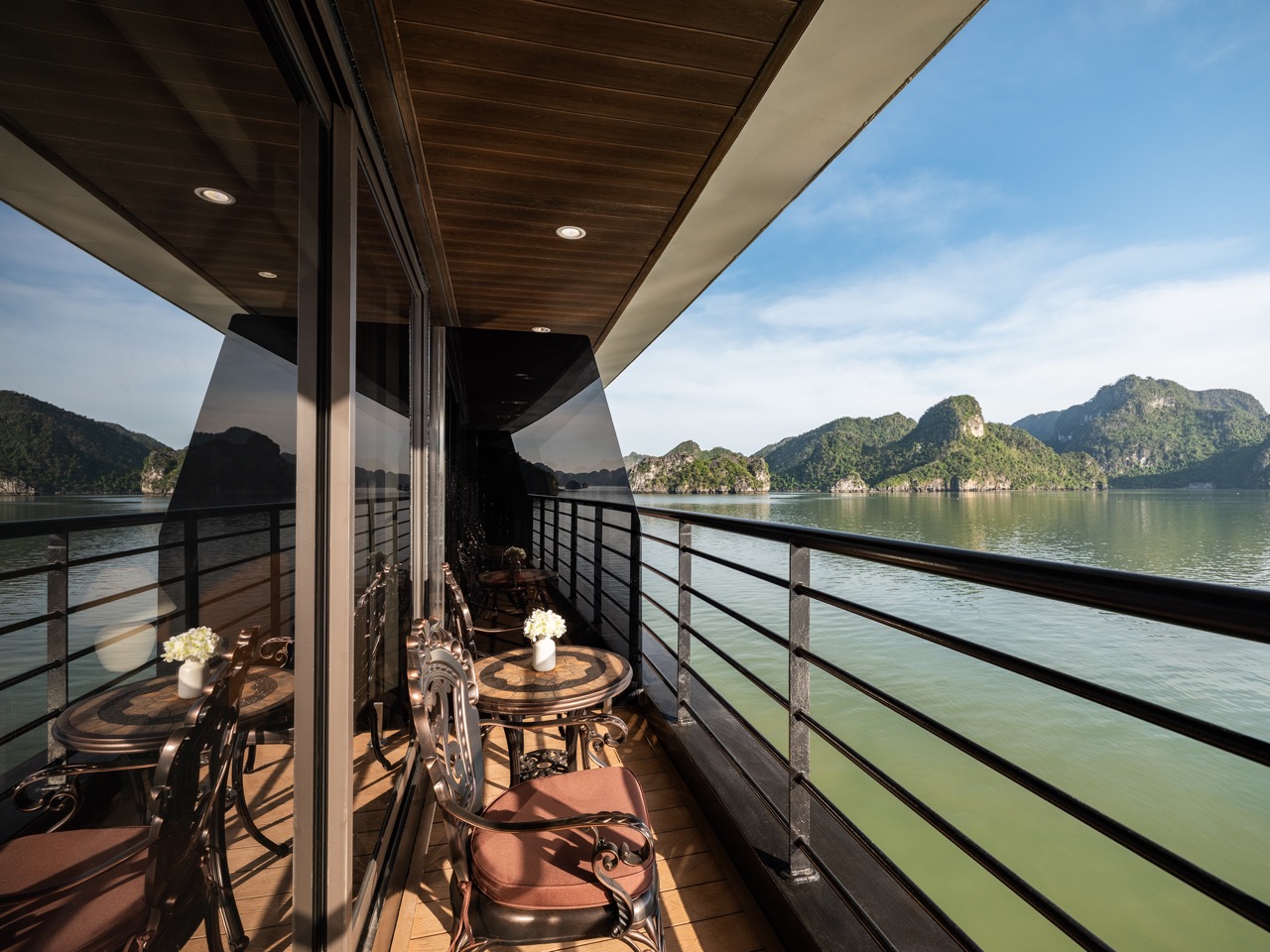 Stunning view from a cruise balcony overlooking Halong Bay's emerald waters and limestone karsts, pe.