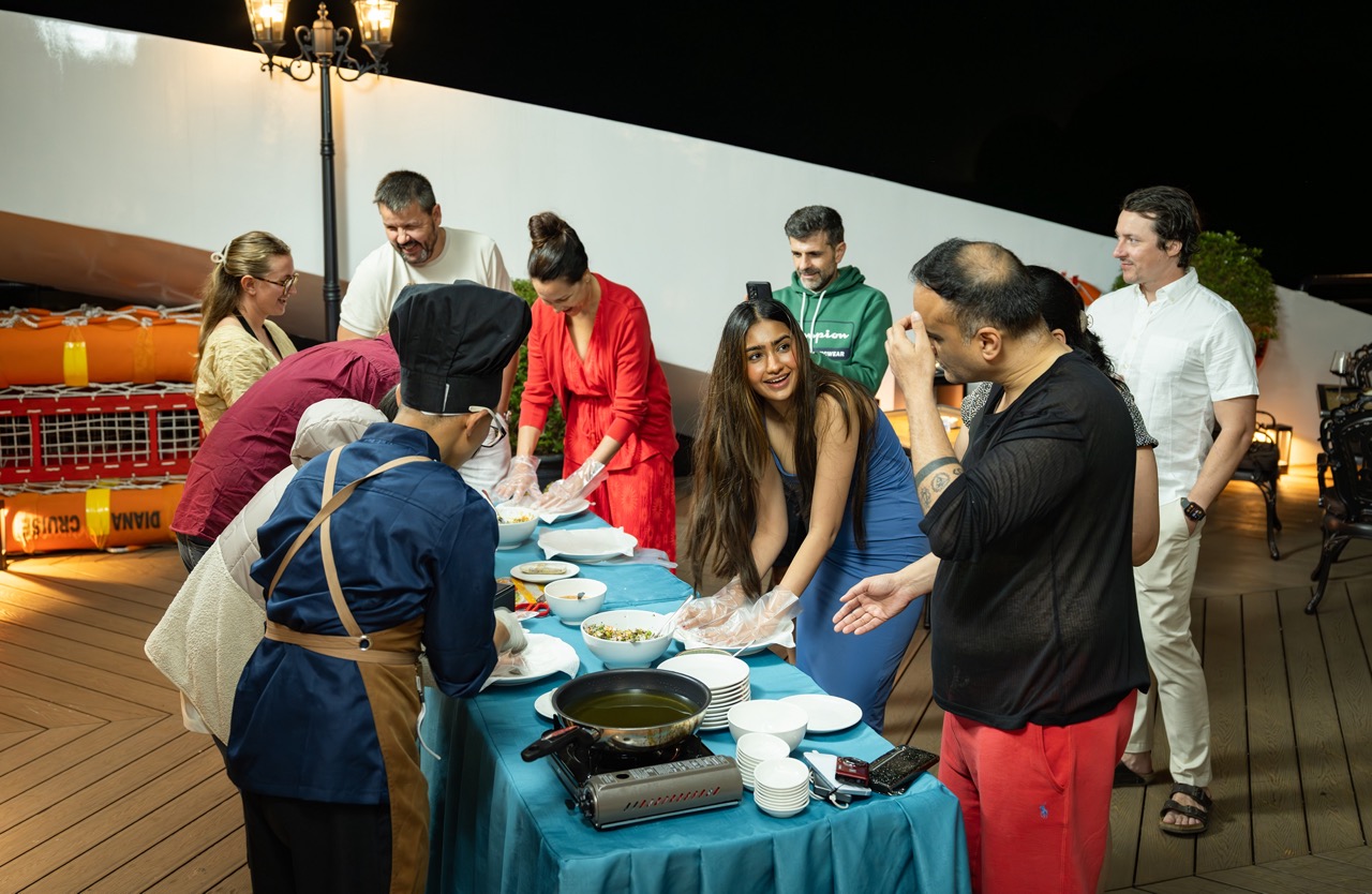 Scenic Lan Ha Bay cruise balcony with travelers enjoying a delicious meal and stunning ocean views.