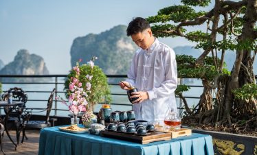 Beautiful scene of a man enjoying a luxurious cruise on Lan Ha Bay with scenic limestone karsts in t.