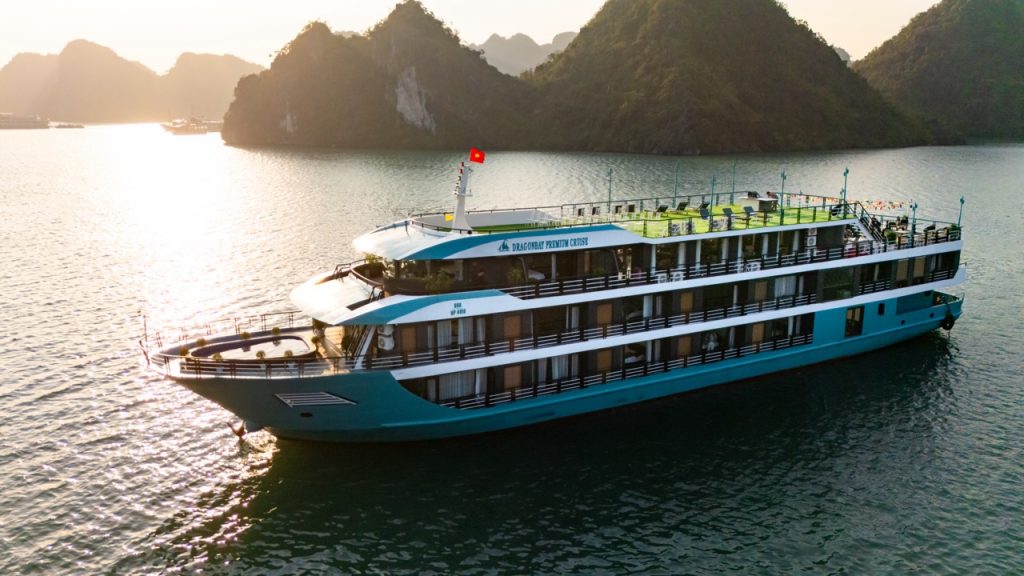 Elegant cruise ship sailing in Lan Ha Bay at sunset, scenic views, relaxing atmosphere.