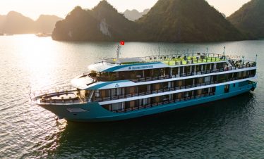 Elegant cruise ship sailing in Lan Ha Bay at sunset, scenic views, relaxing atmosphere.