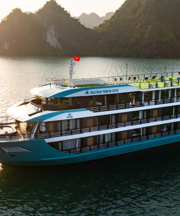 Elegant cruise ship sailing in Lan Ha Bay at sunset, scenic views, relaxing atmosphere.