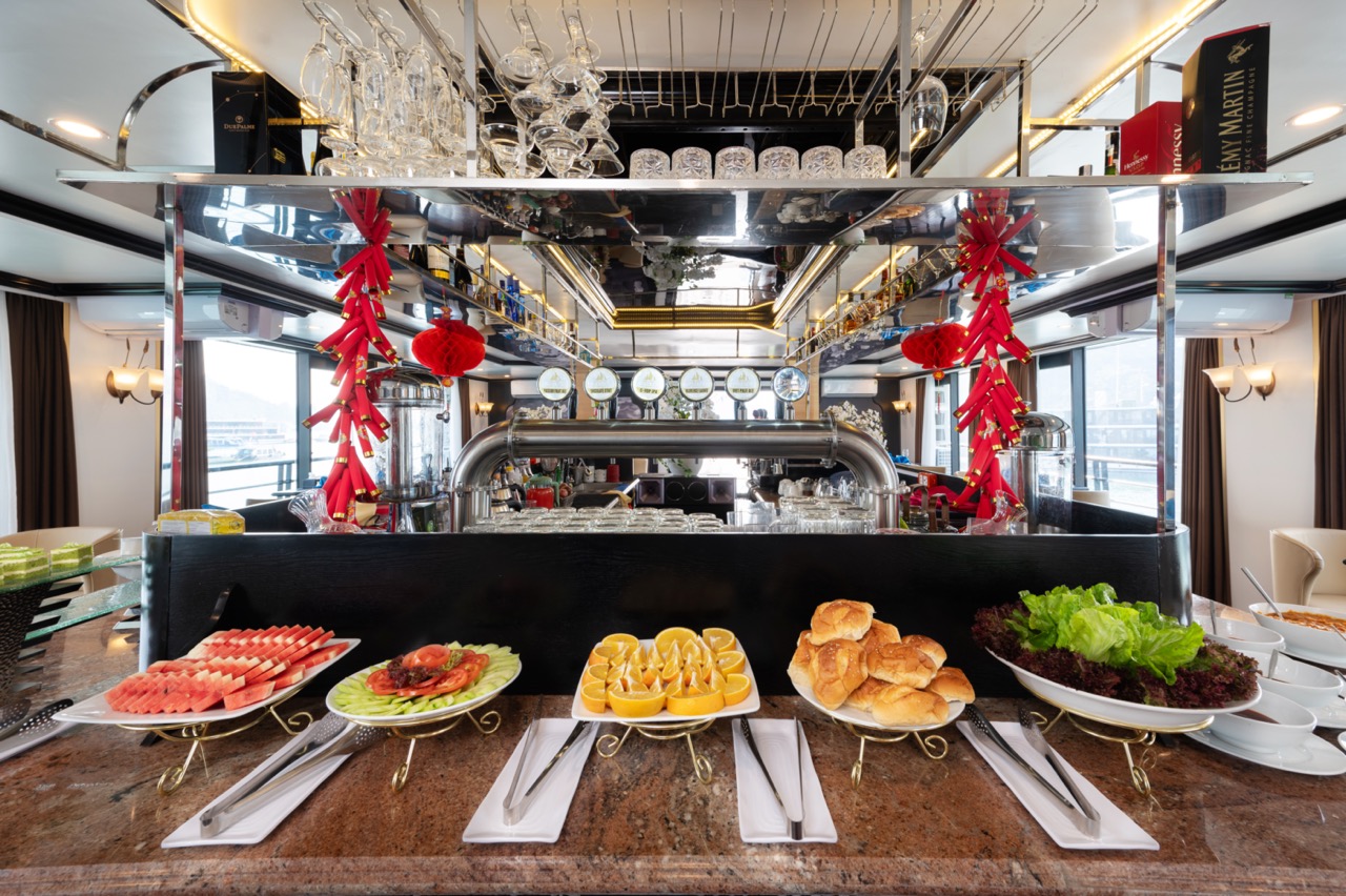 Luxury dining setup with fresh seafood and pastries on Lan Ha Bay cruise balcony, scenic bay view, e.