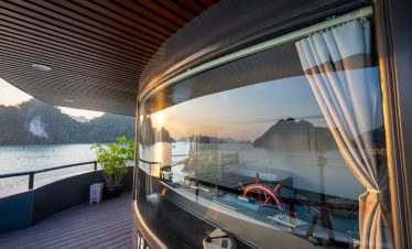 Stunning Halong Bay scenery from cruise balcony with sunset reflection.